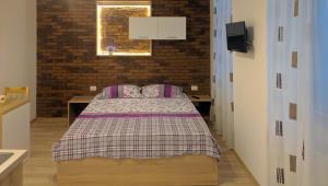 a bedroom with a bed and a brick wall at BrasovApart Piata Sfatului in Braşov