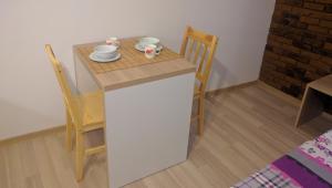ブラショヴにあるBrasovApart Piata Sfatuluiの小さなキッチン(小さなテーブル、椅子付) +2枚の写真
