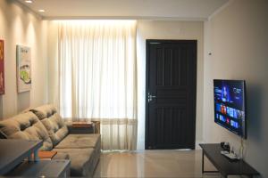 コンボリウーにあるCasa com Jacuzzi, Próximo Teleférico, GreenValley e Praia BC!のソファとテレビのあるリビングルーム