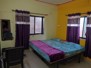 a bed in a room with purple curtains at Shri Samarth Homestay in Diveagar