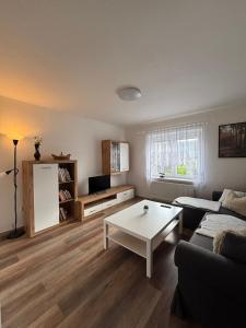 Una sala de estar con un sofá y una mesa de café. en Apartmán na kopečku, en Pernink