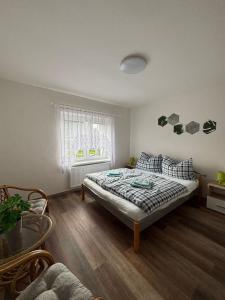 Un dormitorio con una cama en una habitación con ventana. en Apartmán na kopečku, en Pernink