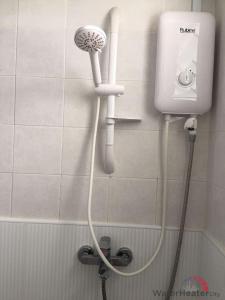 a shower in a bathroom with a hair dryer at Star Holiday in Virār
