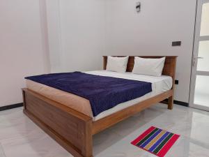 a bedroom with a bed with a blue comforter at Akarsha Residence in Negombo