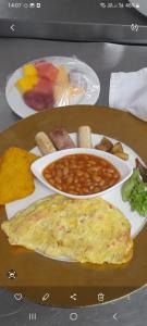 a plate of food with an omelet and beans at Star Holiday in Virār