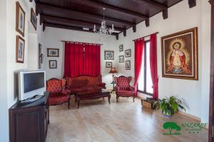 a living room with red chairs and a flat screen tv at Complejo Turístico Rural Nazaret De Moguer in Moguer