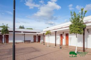 un gran edificio blanco con árboles en el patio en Complejo Turístico Rural Nazaret De Moguer en Moguer