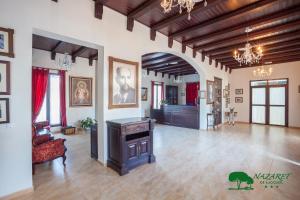 a large living room with a couch and a chandelier at Complejo Turístico Rural Nazaret De Moguer in Moguer