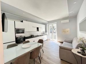 サレルノにあるResidence Arechiのキッチンとテーブルとソファのあるリビングルーム