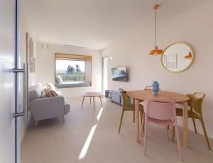 a living room with a dining room table and chairs at Apartamentos Lobamar in Gijón