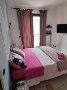 - une chambre avec un lit doté d'une couverture rose et d'une fenêtre dans l'établissement Tenuta Ornella, à Miglianico