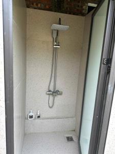 a shower in a bathroom with a light on the wall at Jashill Homestay in Yên Minh +13 photos