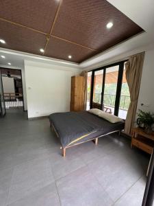 a bedroom with a large bed in a room with windows at Jashill Homestay in Yên Minh