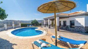AlmácharにあるCasa Adrian Almachar by Ruralidaysのスイミングプールと傘付きの家