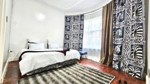a bedroom with a bed and a large window at Jacaranda Escape 4 x King Bed 3 Bath House in Pretoria