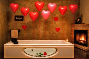 a bath tub with red hearts on the wall at "Il Quercione" Room With SpA in Lama Di Peligni