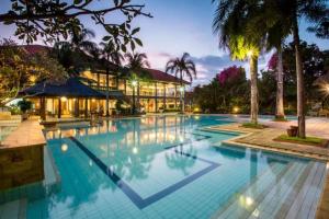 a large swimming pool in front of a building at Kana Suites Jimbaran By Fays Hospitality in Nusa Dua