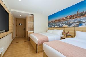 a hotel room with two beds and a flat screen tv at Floral Hotel Beidaihe Migao Intelligent Hotel in Qinhuangdao