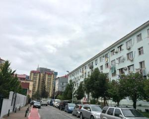 uma rua da cidade com carros estacionados e edifícios em Apartment On Khinikadze 4 em Batumi