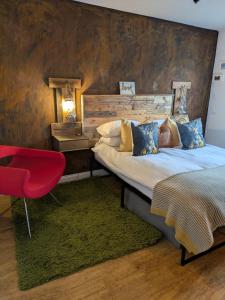 a bedroom with a large bed and a red chair at Boutique Coastal appt nr Edinburgh in Saint Davids