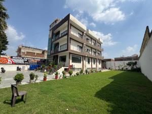a building with a lawn in front of it at Hotel Vrinda Sarovar in Mathura