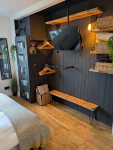 a bedroom with a tv on a wall at Boutique Coastal appt nr Edinburgh in Saint Davids