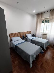 two beds in a room with two windows at Blu Oltremare in Nettuno +9 photos
