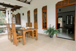 a dining room with a wooden table and chairs at Barefoot Beach - Hiriketiya in Dickwella +36 photos