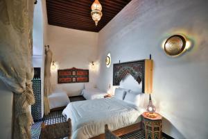 a bedroom with a king sized bed and a table at Dar Elinor Fez in Fès