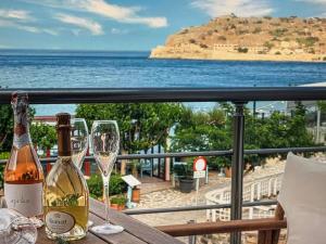 - une table avec 2 bouteilles de vin et des verres sur le balcon dans l'établissement Sea view, à Elounda