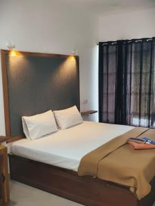 Vagamon Hill Resort في فاغامون: غرفة نوم بسرير كبير مع وسائد بيضاء +صورة واحدة