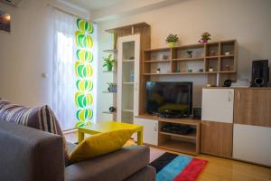 een woonkamer met een bank en een televisie bij Blue Lake Apartment in Zagreb