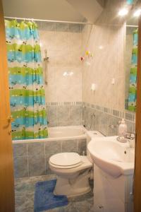 a bathroom with a toilet and a sink and a tub at Blue Lake Apartment in Zagreb