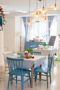 a dining room table with blue chairs and a table with a white table cloth at Hando • Cape Seven Seaside Villa in Qingdao