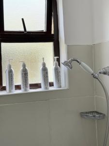 a bathroom with four bottles sitting on a window sill at Namelok apartment in Sekenani