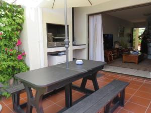 a table and two benches in a living room at No. 1 Arrowood, Plettenberg Bay in Plettenberg Bay