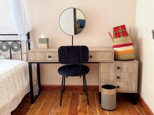 a bedroom with a desk with a mirror and a chair at Namelok apartment in Sekenani
