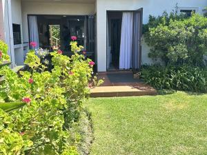 a front door of a house with a cat in the yard at No. 1 Arrowood, Plettenberg Bay in Plettenberg Bay