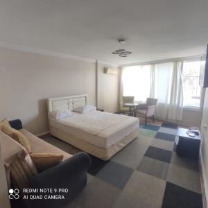 a hotel room with a bed and a couch at Evim Butik Otel in Seyhan