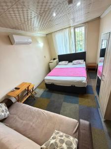 a small room with a bed and a couch at Evim Butik Otel in Seyhan