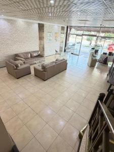 a large living room with couches and tables in a building at Evim Butik Otel in Seyhan
