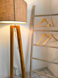 a lamp next to a shelf with hangers at Le Rodrigues - plages - parking - clim - wifi in Saint-Gilles les Bains