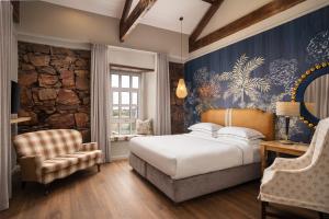 a bedroom with a bed and a stone wall at Protea Hotel by Marriott Mossel Bay in Mossel Bay +153 photos