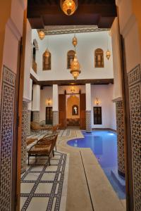 an indoor pool in a hotel with pendant lights at Dar Elinor Fez in Fès