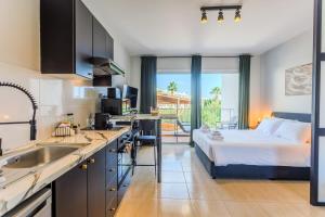 a kitchen and a bedroom with a bed in a room at estéa - Peyia's Pearl - Holiday Studio in Peyia