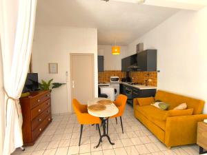 a living room with a couch and a table at Le Rodrigues - plages - parking - clim - wifi in Saint-Gilles les Bains +7 photos