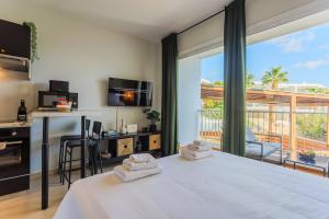 a bedroom with a bed and a large window at estéa - Peyia's Pearl - Holiday Studio in Peyia