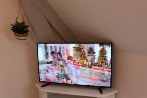 a flat screen tv sitting on a table with christmas trees at Escapade au Mont St Michel in Pleine-Fougères
