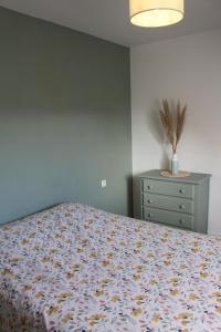 a bedroom with a bed and a dresser at Escapade au Mont St Michel in Pleine-Fougères