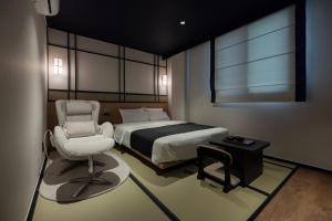 a bedroom with a bed and a chair in it at Mitasuya Ryokan Hotel Daejeon Yongjeon in Daejeon